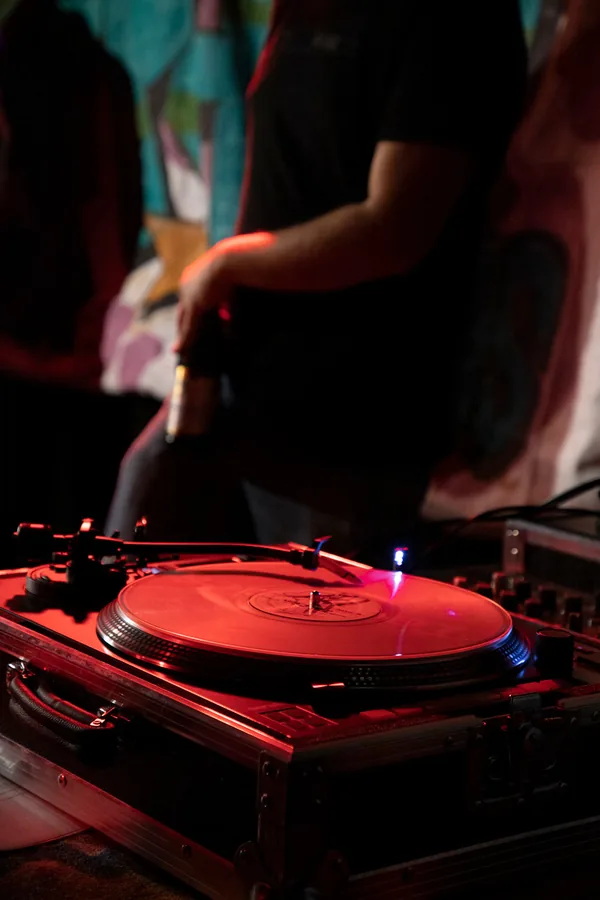 Hand eines DJs auf einer Schallplatte am Plattenteller